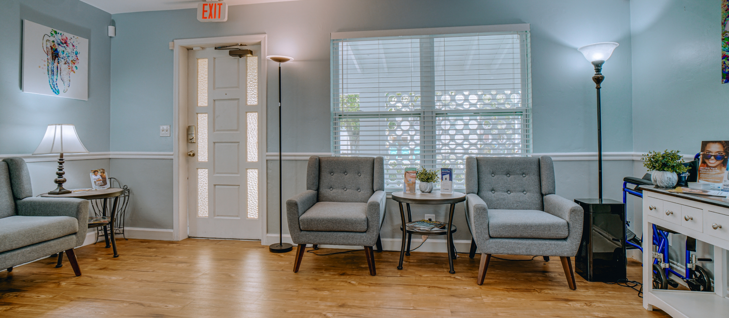 Waiting area with comfortable armchairs and pale blue walls in Boynton Beach dental office