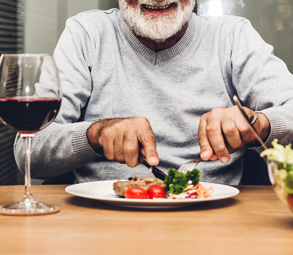 Senior man eating a plate of vegetables