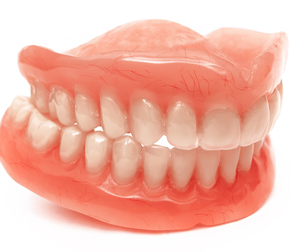 Set of full dentures against white background