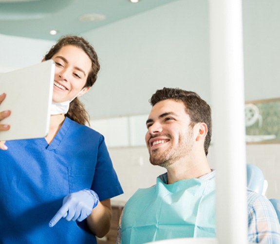 Dentist showing patient image on tablet