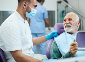 Patient smiling at dentist while holding mirror