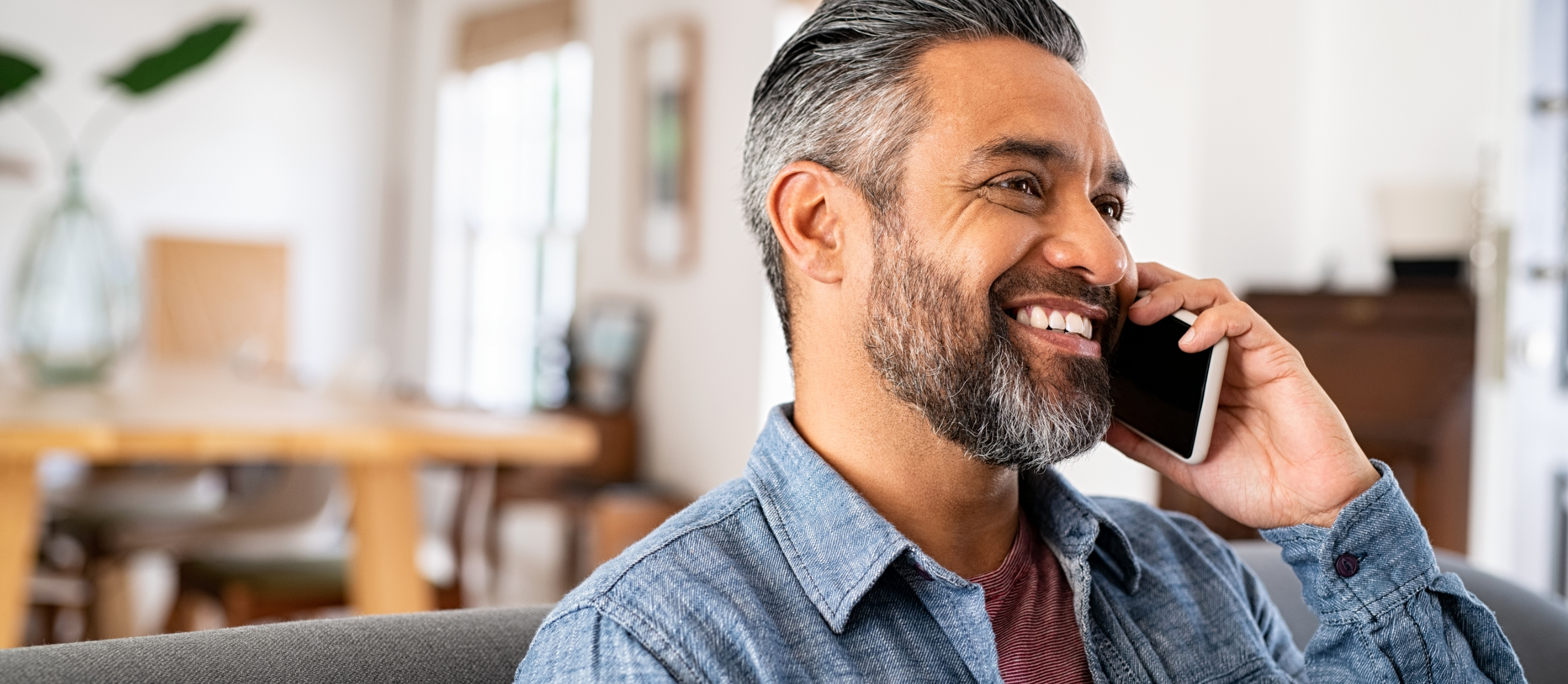 Man smiling while talking on the phone