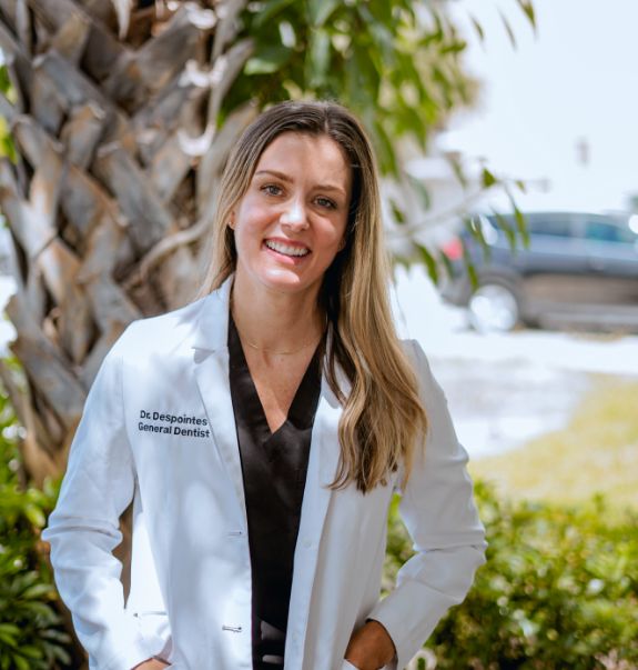 Boynton Beach dentist Doctor Aurelie Huyghues Despointes smiling outdoors in white lab coat