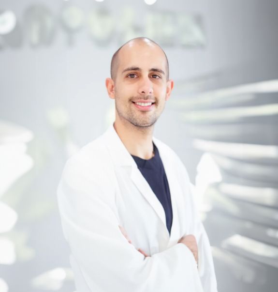 Boynton Beach dentist Doctor Camilo Rodriguez smiling in a white lab coat