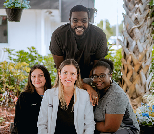 Doctor D smiling with three dental team members