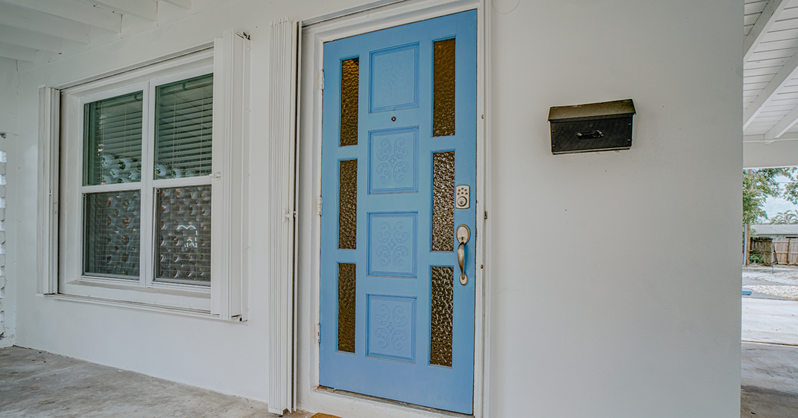 Pale blue front door of dental office