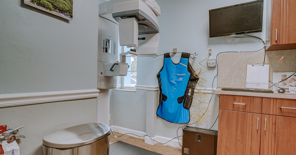 Cone beam scanning machine standing against wall in dental office