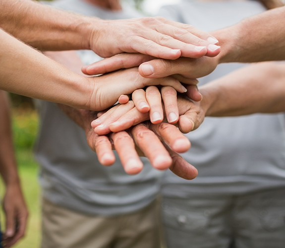 Circle of people putting their hands together in the middle