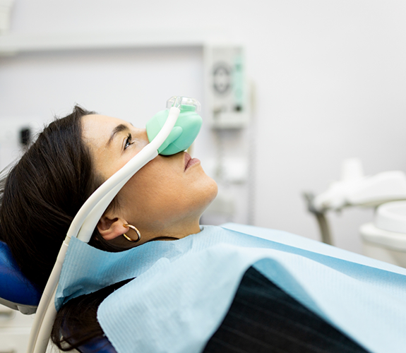 Woman in dental chair with a nitrous oxide mask over her nose