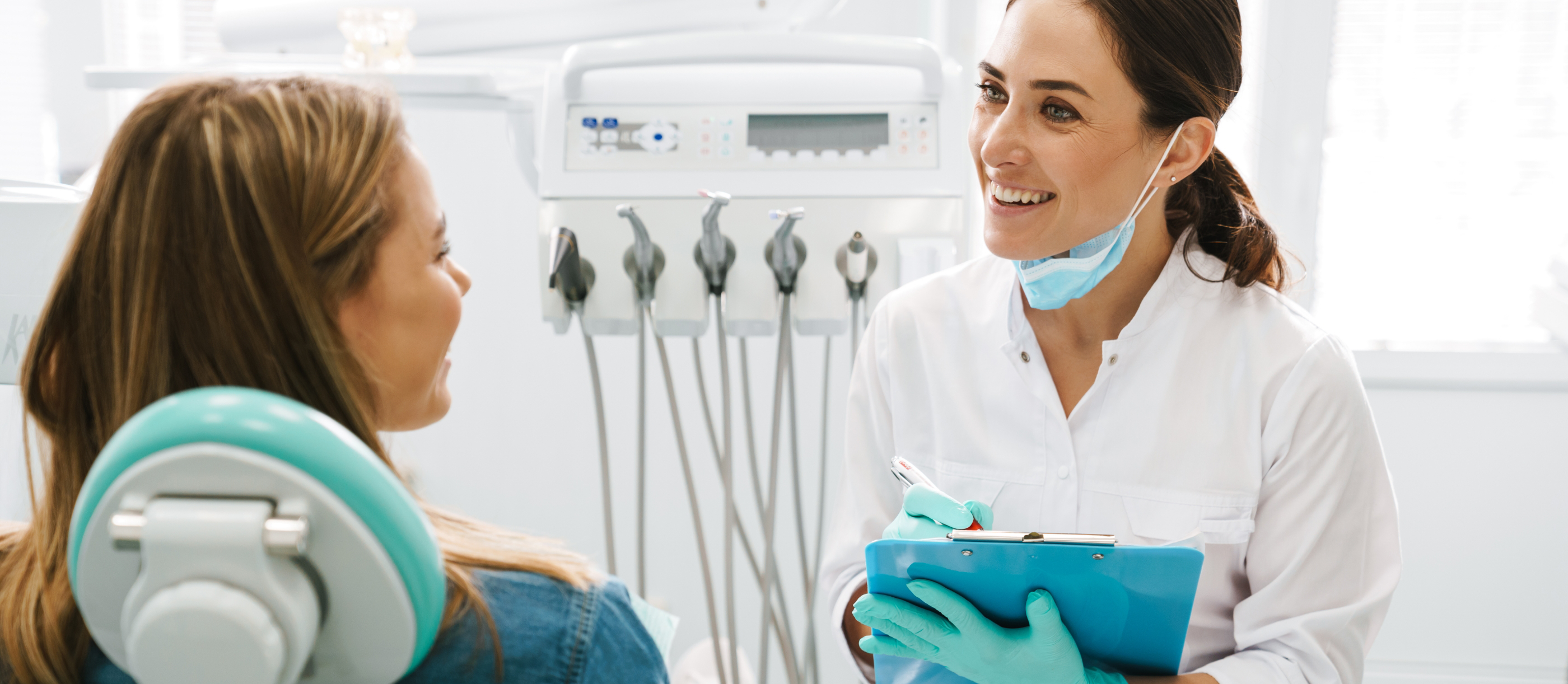 Dentist talking to a smiling patient after tooth extractions in Boynton Beach