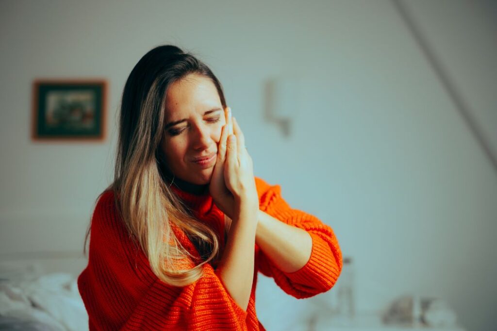 A woman holding her face in pain.